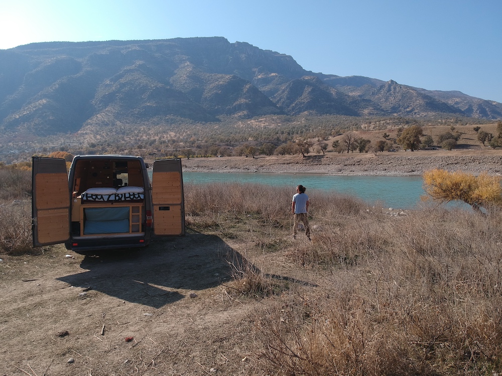 man and van parked by lake - vanlife journey in Iraq's Kurdistan