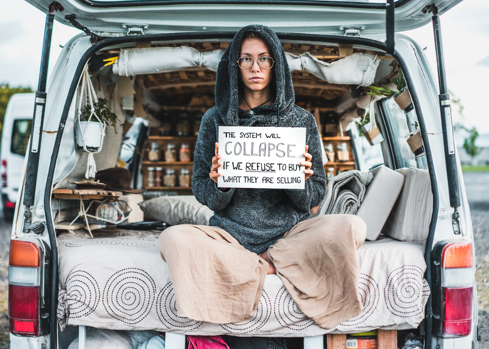 women holds responsible vanlife sign in back of van