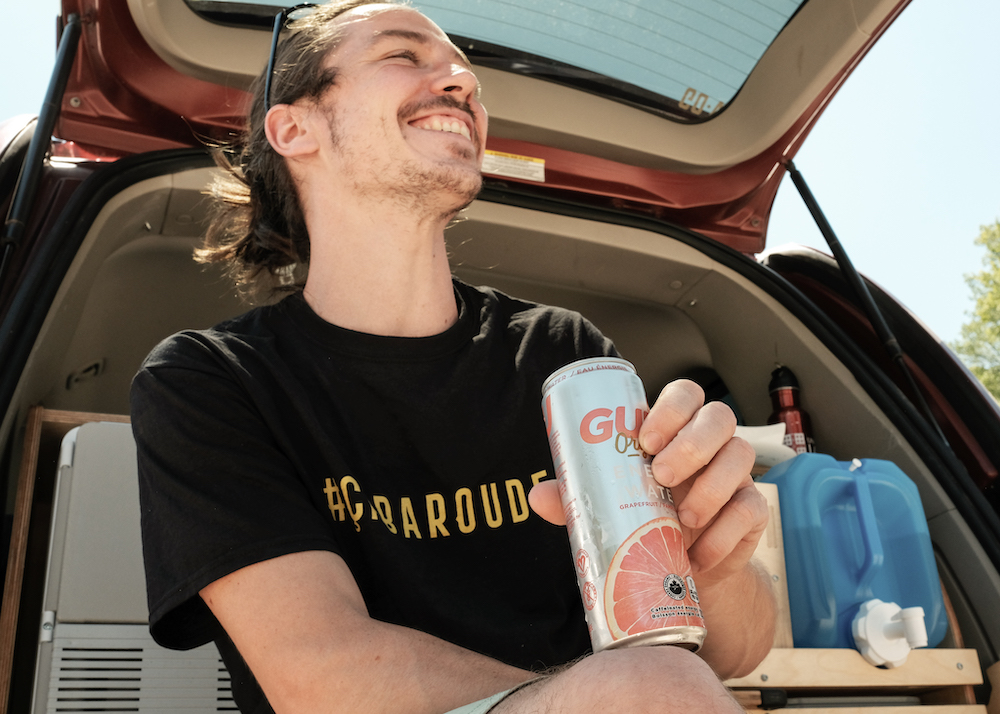 man drinking energy drink - road trip en paddleboard au Québec