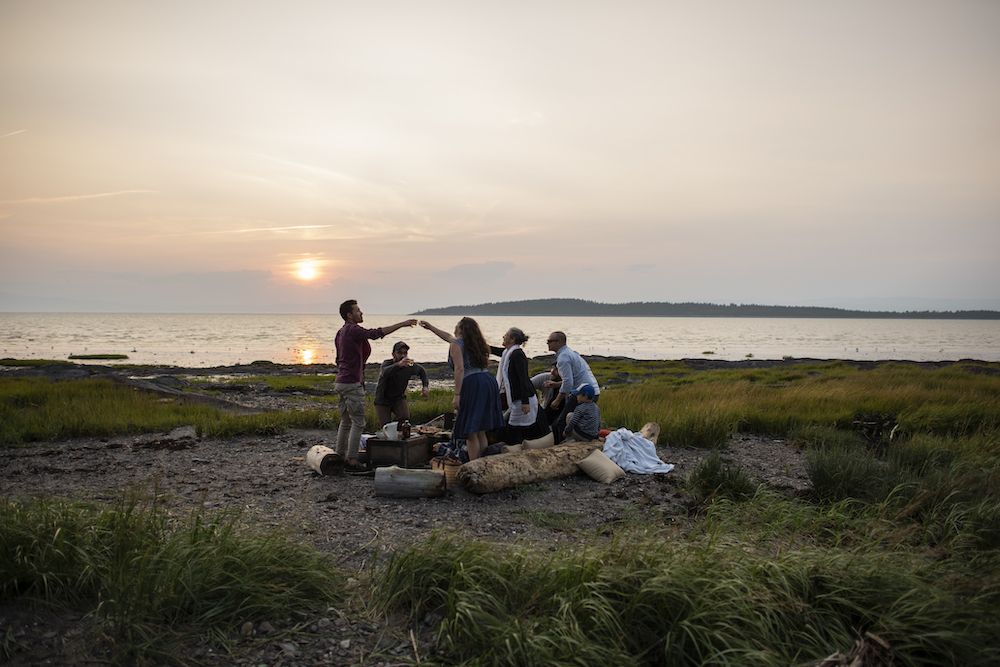 group doing cheers on beach - campervans à louer Québec