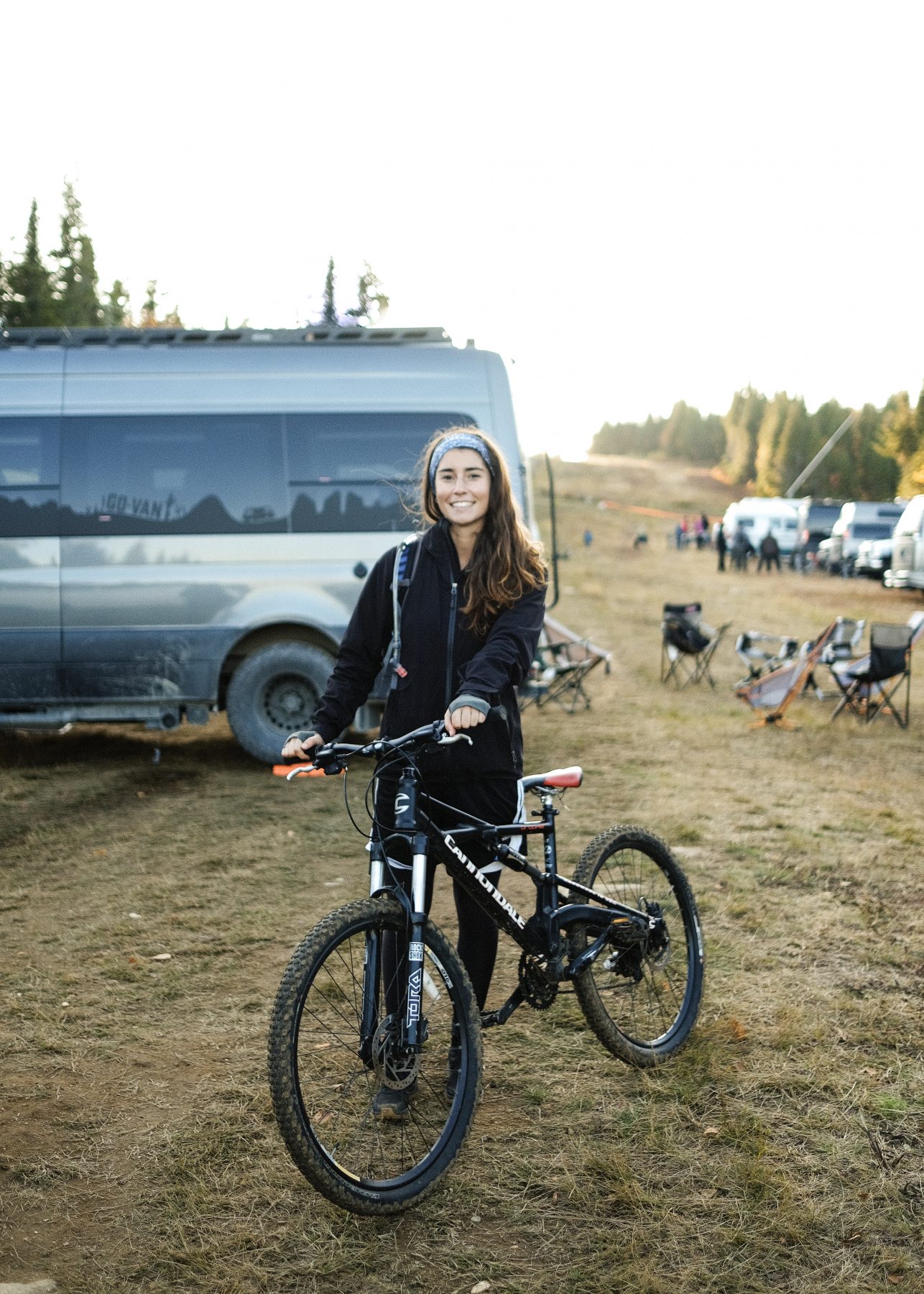 girl holding bike in front of van - vélo de montagne van life