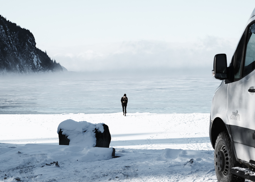 Femme devant lac - Vanlife en hiver