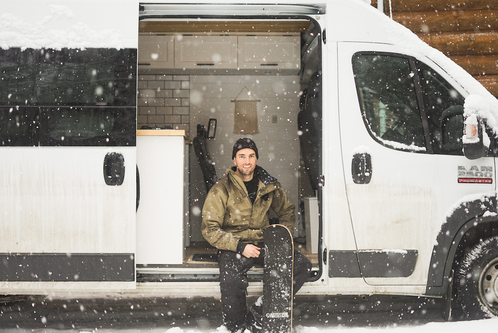 Homme dans un Sprinter van avec planche à neige