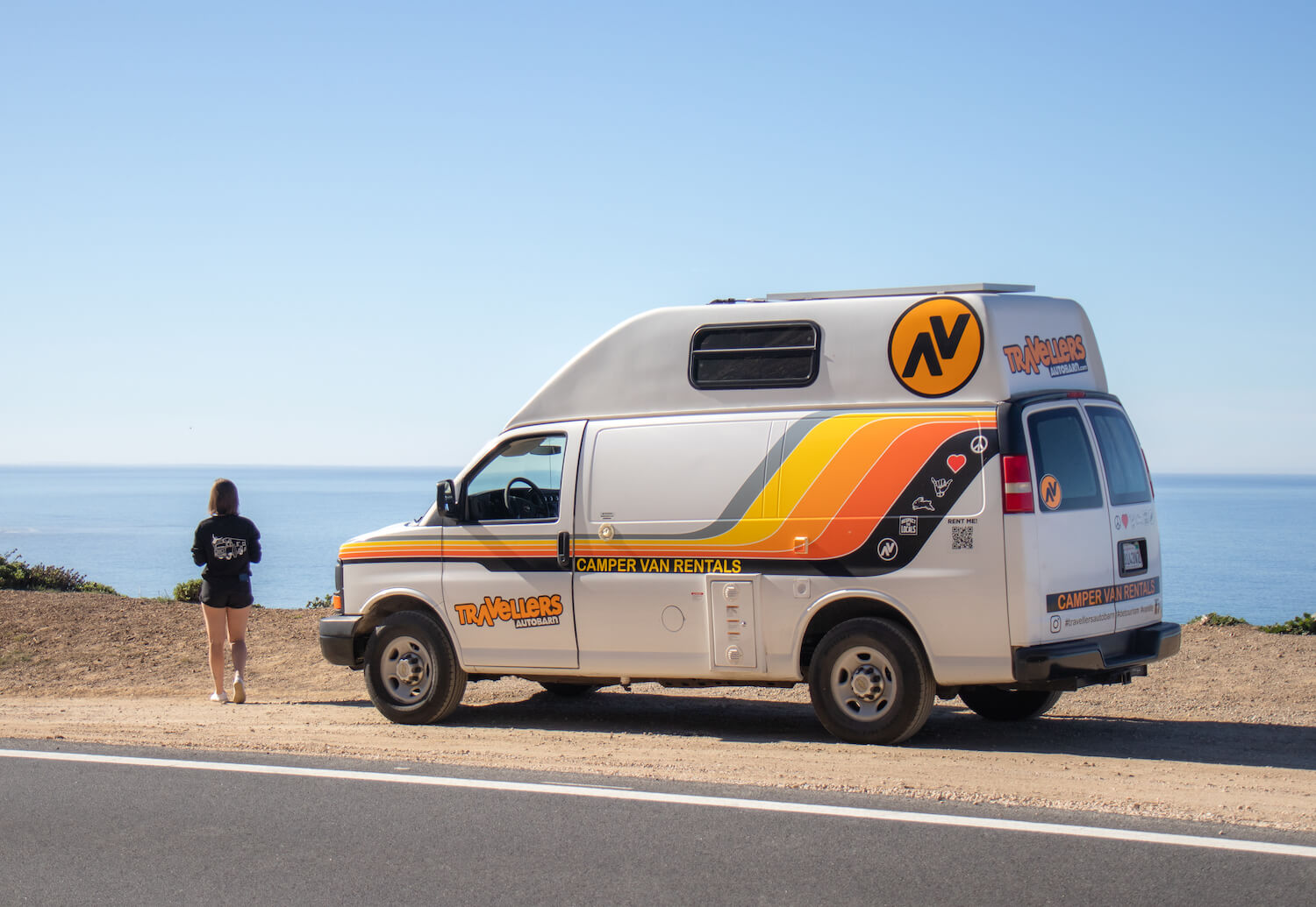 girl with traveller autobarn van on california coast